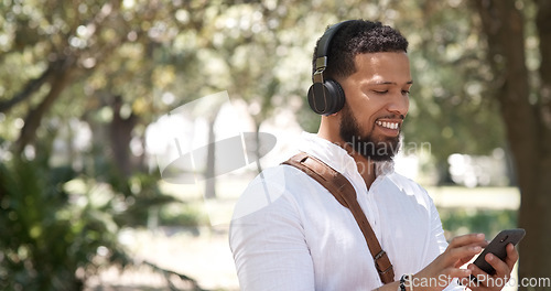 Image of Businessman, typing and phone music in nature, communication and chat in the morning. Smile, young and employee listening to a podcast, radio or streaming audio on a mobile in a park for a commute