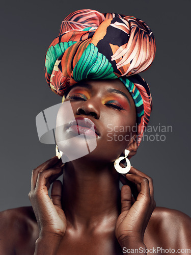 Image of Beauty, Cosmetic and woman with a turban in studio with a elegant, glam and makeup face. Classy, jewelry and young African female model with a head wrap doing sensual pose isolated by gray background