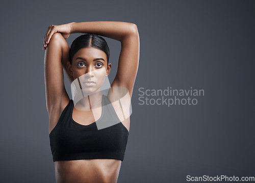 Image of Focus, mockup and stretching with an athlete woman in studio on a gray background for fitness or health. Exercise, mindset and warm up with an attractive young female model training her body