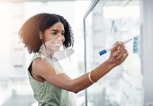 Image of Business, glass wall and black woman writing, plan or strategy in office. Brainstorming, board and happy female person write idea, working on project and schedule, notes or information in workplace.