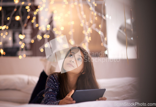 Image of Thinking, tablet and children with a girl in her home, lying on the living room floor to relax or daydream. Kids, idea and technology with a young female child browsing the internet in her house