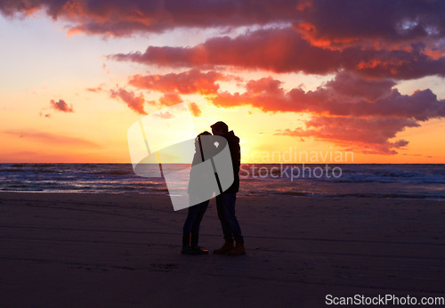 Image of Kiss, silhouette people together at sunset and on seaside together for honeymoon. Care or love, holiday and shadows of couple on the beach or sea for romantic date outdoor on summer vacation