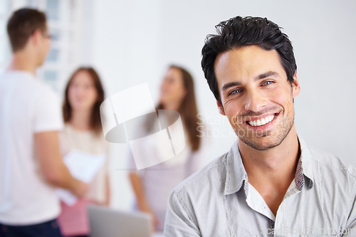 Image of Happy, work and portrait of a man in an office with business people for commitment and our vision. Smile, working and face of a corporate employee at a company with workers at a professional agency