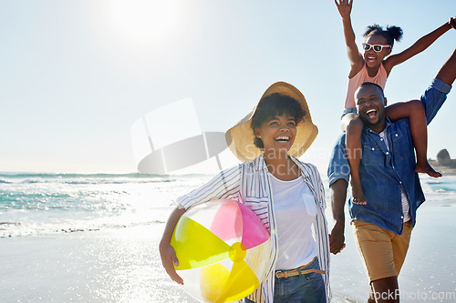 Image of Black family, beach ball and summer at the beach while happy and walking together holding hands. Man, woman and a girl child excited about holiday at the ocean with freedom, happiness and fun outdoor