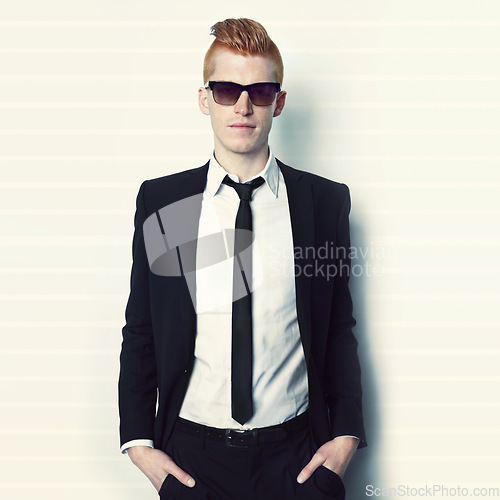 Image of Fashion, suit and portrait of a man in a studio with sunglasses and a stylish formal outfit.Young, cool and handsome male model with elegant trendy style and confidence isolated by a white background