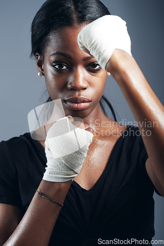 Image of Portrait, fighting and a woman boxer in studio on a gray background for self defense, fitness or training. Health, exercise and workout with a black female fighter practising for a boxing competition