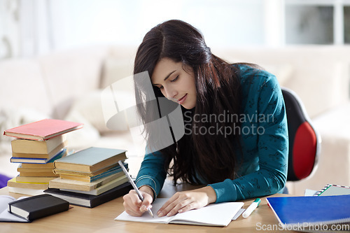 Image of Books, education and girl writing in book for learning, assignment or homework in her home. Student, female and notebook at table for project, planning and brainstorming, creative and idea notes