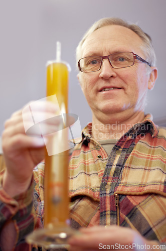 Image of Beer, brewing and glass tube with a man in a plant, factory or warehouse for the production of alcohol. Manufacturing, industry and career with a male brewer in a distillery for quality control