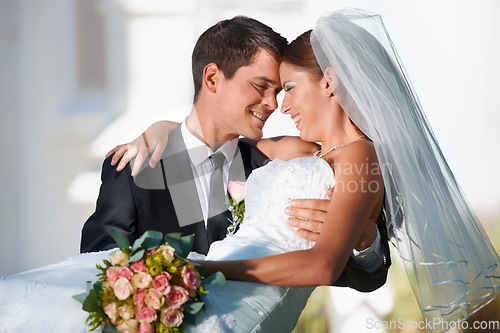 Image of Wedding, marriage or carry with a bride and groom in celebration outdoor as a newlywed married couple. Smile, romance and tradition with a man carrying a woman over the threshold after a ceremony