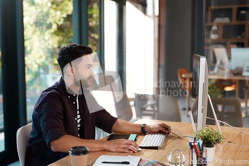 Image of Office, designer and man working on computer at desk while online for research or creative work. Male entrepreneur person at workplace with internet connection for business project or reading email