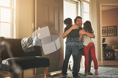 Image of Home, love and a father hugging his kids after arriving through the front door after work during the day. Greeting, family or children with a man holding his son and daughter in the living room