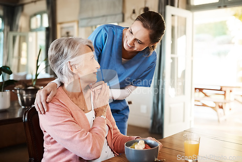 Image of Healthcare, elderly woman with nurse with breakfast at her home and at the table in living room. Support or communication, caregiver and conversation with medical person with senior or old female.