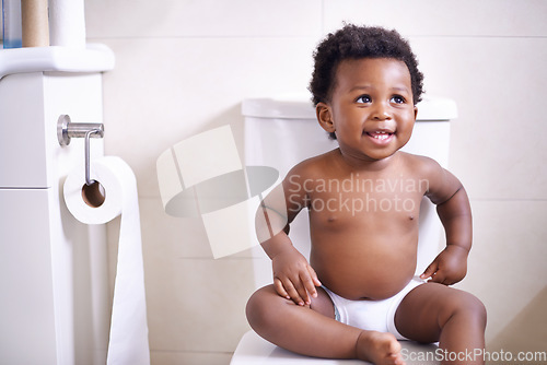 Image of Baby boy, toilet and smile in house, learning and African childhood development with potty training. Young toddler, black child or kid sitting in bathroom with diaper, growth and happiness in home