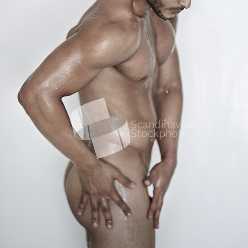 Image of Sexy, naked man and shower or nude body with torso or clean skin and for abs care on white background. Seductive, male model and bodybuilder or closeup of shirtless and muscular guy in studio.