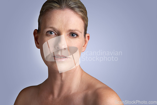 Image of Face, beauty and portrait of mature woman doing cosmetic skincare facial isolated in a blue studio background. Cosmetics, care and old female model calm with natural skin due to anti aging