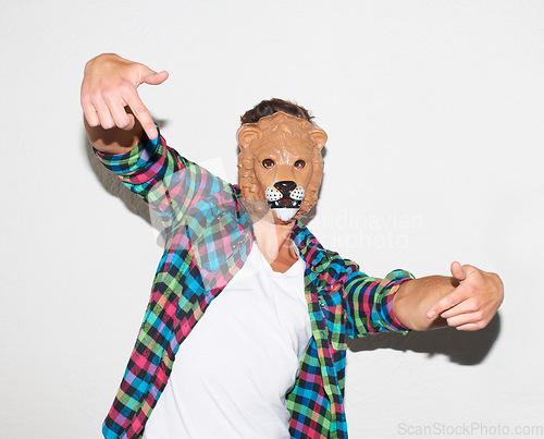 Image of Animal mask, hand gesture and a man in studio with cool attitude to party with a positive mindset. Lion face or male model person isolated on a white background for fun, funny and goofy portrait