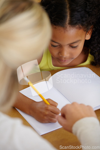 Image of Teacher help student, education and writing in notebook with pencil, teaching and learning for growth and development. People in classroom to learn, academic study with young girl and woman at school