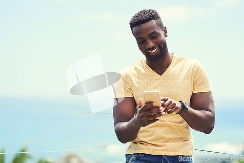 Image of Black man, phone and typing on social media, app or text and message, communication and mockup blue sky background. Smartphone, online networking or internet conversation on screen with smile