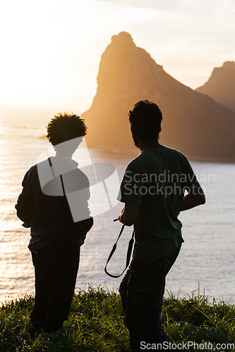 Image of Men, silhouette and mountain with sunset, ocean or travel in summer, vacation or outdoor for horizon view. People, hiking adventure and rest on hill for sea, sunshine or relax on holiday with freedom