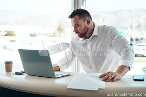 Image of Laptop, documents and car sales man with invoice, quote and financial report for retail or transportation industry. Focus, busy and professional dealership person or boss on computer with paperwork