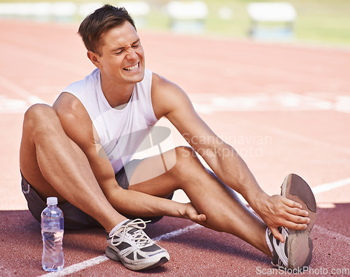 Image of Athlete, leg pain and man with injury outdoor after exercise, running or workout at a sports stadium. Male person on ground with muscle problem, accident or burnout while training for body fitness