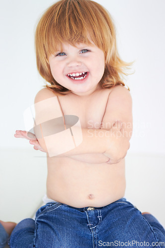 Image of Young kid, laughing and arms crossed portrait of a toddler in studio with a smile. Ginger infant, laugh and happy in a house with joy and positivity from childhood isolated with white background