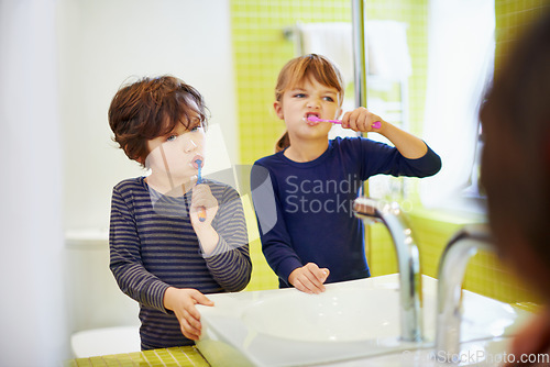 Image of Children brushing teeth in home bathroom with toothbrush for hygiene and clean mouth. Oral healthcare or fresh breath, kids grooming while bonding and wellness with dental care at sink for dentist