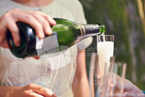 Image of Hand, pour champagne and glasses for group of friends for celebration, toast and party in park, garden or nature. Bottle, sparkling wine and glass to celebrate for team of people, birthday or event