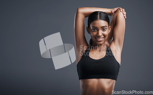 Image of Portrait, mockup and stretching with an athlete woman in studio on a gray background for fitness or health. Exercise, workout and warm up with an attractive young female model training her body