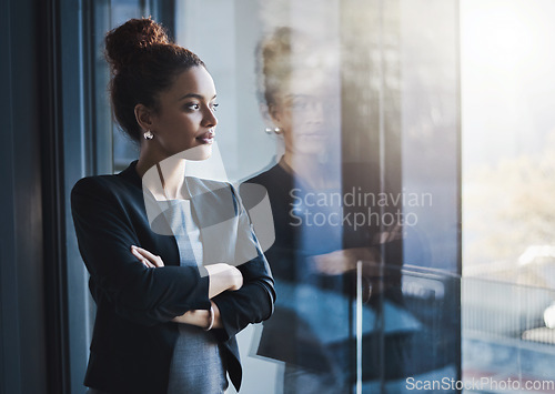 Image of Business woman, window and thinking for vision, goals and future of career with ideas, mission and mindset. Young businesswoman, focus and ambition in workplace with memory, reflection and dream