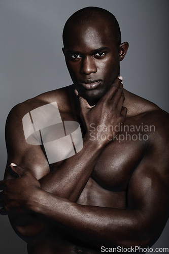 Image of Muscle, body and skin, portrait of black man on dark background with and serious face for art aesthetic. Health, wellness and sexy, fit African bodybuilder or male model isolated on studio backdrop