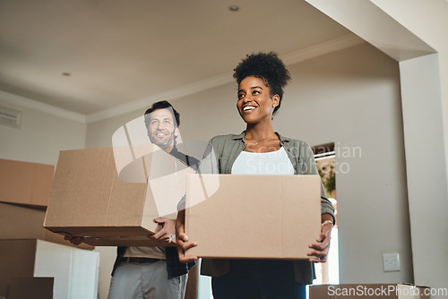 Image of Happy couple, real estate and moving in with boxes for renovation, investment or relocation in new home. Interracial man and woman realtor owner carrying box in house, move or property loan together