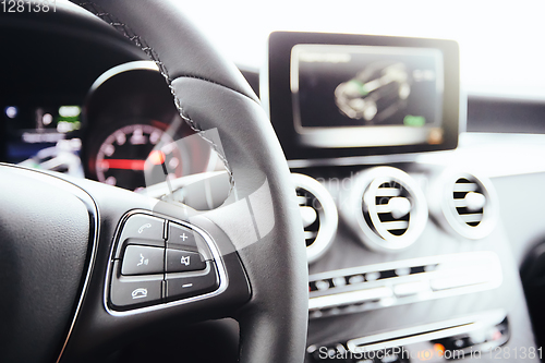 Image of Control buttons on steering wheel. Car interior.