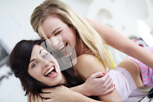 Image of Portrait, hug and friends in a bedroom having fun, laughing and happy at a sleepover. Face, crazy and women joke, playful and embracing in a bedroom, bonding and smile while joking in their home