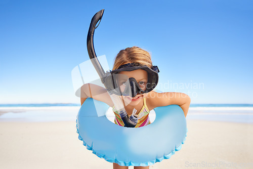 Image of Portrait, beach and child with goggles and inflatable gear for swimming, summer holiday and happy outdoor adventure. Face of kid excited standing by the ocean or sea water excited for vacation