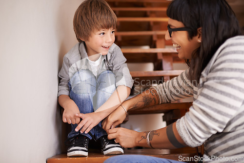 Image of Learning, tying and shoes with mother and kid for child development, bonding and helping. Happy, smile and support with woman and young boy on steps in family home for laces, care and happiness