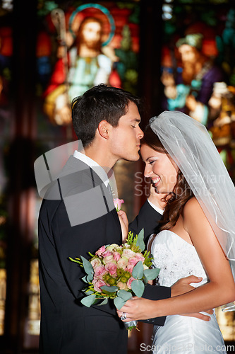 Image of Wedding, marriage or ceremony with a bride and groom in a church or chapel for the tradition of vows. Married couple, love or trust with a man kissing a woman on the forehead as newlywed people