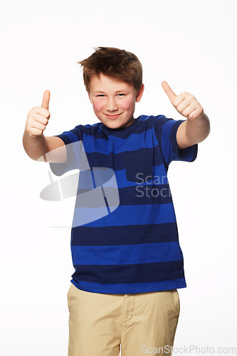 Image of Portrait, thumbs up and smile of kid in studio isolated on a white background. Boy, hand gesture and child with like emoji for agreement, success or thank you, yes sign and winner, ok and approval.