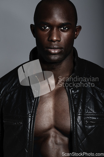 Image of Fashion, portrait and black man in leather jacket in studio isolated on a gray background. African male model, serious face and coat, confidence and stylish clothes or trendy outfit from Nigeria.