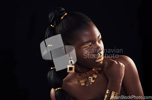 Image of Gold, beauty and black woman in studio for makeup, art and elegance against a black background. Rich, creative and African female model pose with jewelry for wealth, royal and luxury queen aesthetic
