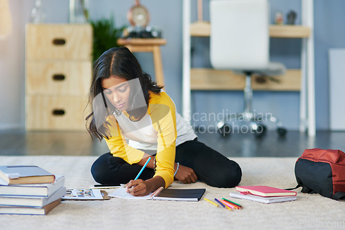 Image of Education, student and woman writing in notebook, journal or planner for research report, project or information summary. College learning, university study and Indian person studying on home floor