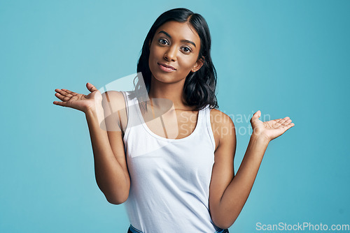 Image of Choice, portrait and woman with option gesture in studio with question, thinking and doubt symbol. Decision, balance and female model with comparison or shrug hand sign by blue background with mockup