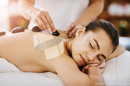 Image of Therapy, relax and woman getting a hot stone back massage at spa for luxury, calm and natural self care. Beauty, body care and tranquil female person sleeping while doing rock body treatment at salon