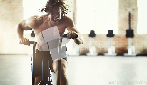 Image of Workout, fitness and man on elliptical in gym for health, training or exercise. Sports, motivation and determined male shouting on cross trainer bike for exercising, cardio and cycling for strength.