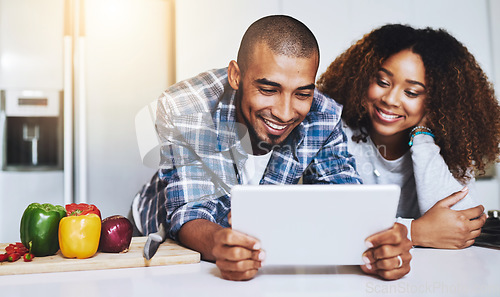 Image of Happy couple, tablet and cooking healthy meal with recipe in kitchen at home on internet, website and online connection. Man, African woman and technology for reading instructions on vegan food blog