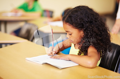 Image of Education, learning and girl in a classroom, writing and focus with notes, book and homework. Female child, student and kid with development, growth and knowledge for the future, creative and exams