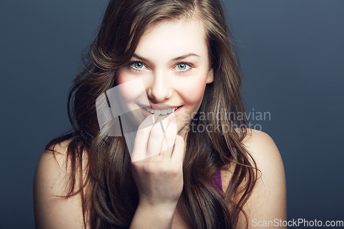 Image of Beauty, face and skin portrait of a woman in studio with a smile, makeup and cosmetics. Headshot of a happy gen z female model on a grey background for natural glow, hair care and dermatology