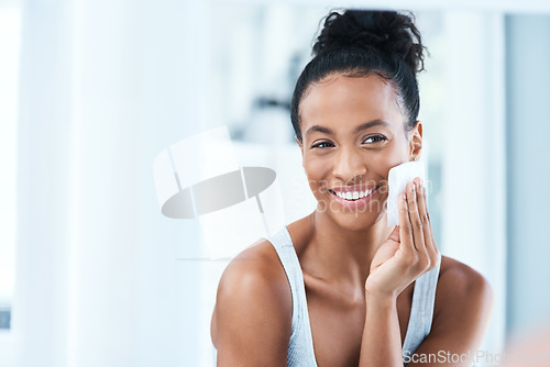 Image of Skincare, black woman with cotton pad on face and smile, makeup cleaning and luxury skin product in bathroom. Dermatology, cosmetics and beauty facial, African model with cleansing pads and mock up.