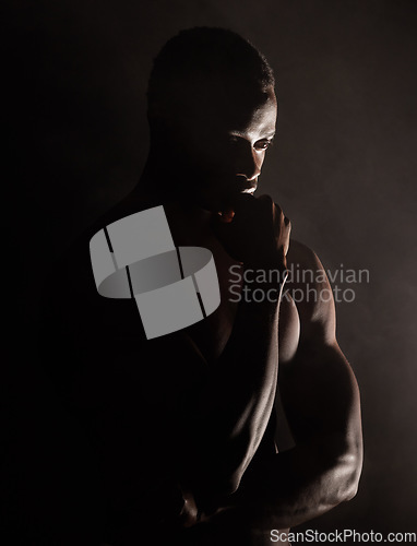 Image of Black man, muscle silhouette and studio for thinking, anxiety and depression with art deco vision. Model, art aesthetic and depressed with strong body, alone or suffering with mental health in shadow