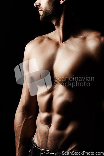 Image of Closeup, muscular and man with fitness, stomach and sexy against a dark studio background. Zoom, male person or confident model with wellness, healthy lifestyle or bodybuilder with muscle and abdomen